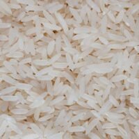 Detailed view of uncooked white rice grains, showcasing texture and pattern.